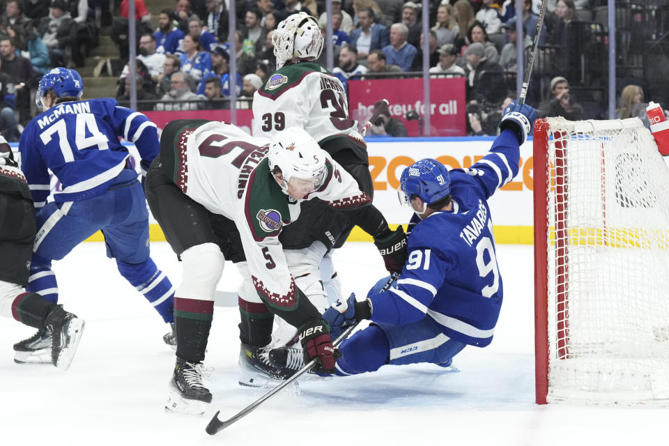 Arizona Coyotes' Michael Kesselring (5) checks Toronto Maple Leafs' John Tavares (91) during second-period NHL hockey game action in Toronto, Thursday, Feb. 29, 2024. (Chris Young/The Canadian Press via AP)
