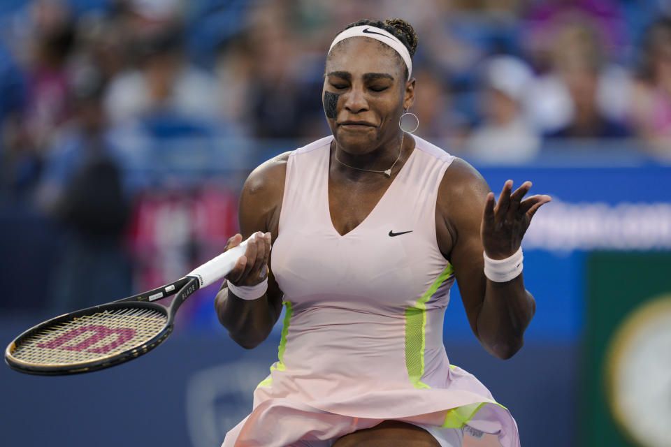 La estadounidense Serena Williams alza las manos tras perder un punto ante la británica Emma Raducanu, durante el torneo de Cincinnati, el martes 16 de agosto de 2022 (AP Foto/Jeff Dean)