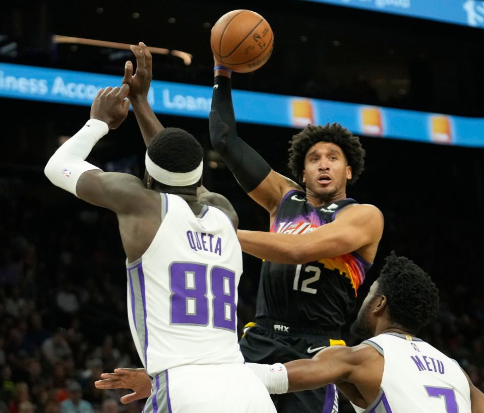 Apr 10, 2022; Phoenix, Ariz. U.S.;  Phoenix Suns forward Ish Wainright (12) passes the ball against Sacramento Kings center Neemias Queta (88) and forward Chimezie Metu (7) during the second quarter at Footprint Center.