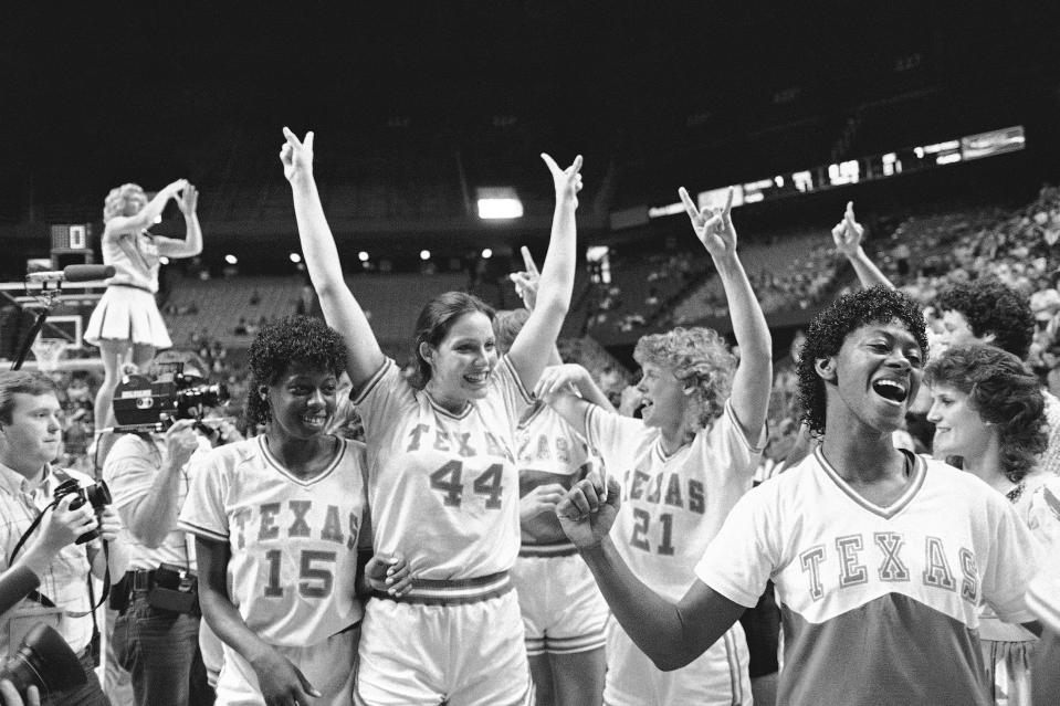 FILE - Texas players Annette Smith (15), Cara Priddy (44) and Paulette Moegle (21) celebrate following their 94-78 win over the University of Southern California at the NCAA Women's Championship at Rupp Arena, Sunday, March 31, 1986 in Lexington, Ky. (AP Photo/Gary Landers, File)
