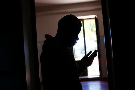 An adolescent migrant uses his mobile phone at an immigration centre in the Sicilian town of Caltagirone, Italy April 20, 2016. REUTERS/Tony Gentile