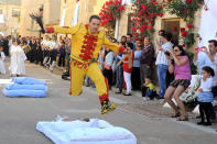 BURGOS, SPAIN - JUNE 10: A man representing the devil leaps over babies during the festival of El Colacho on June 10, 2012 in Castrillo de Murcia near Burgos, Spain. The festival, held on the first Sunday after Corpus Cristi, represents the devil taking away original sin from the newly born babies by leaping over them. (Photo by Denis Doyle/Getty Images)