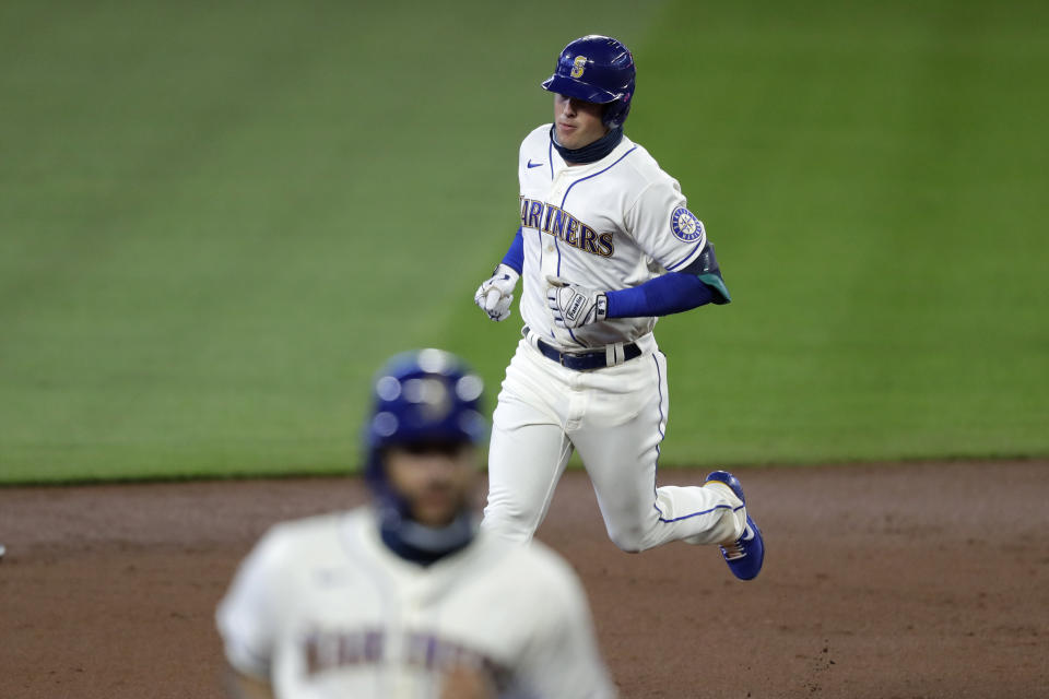 Seattle Mariners' Dylan Moore, top, follows J.P. Crawford around the bases after hitting a two-run home run against the Colorado Rockies in the first inning of a baseball game Sunday, Aug. 9, 2020, in Seattle. (AP Photo/Elaine Thompson)