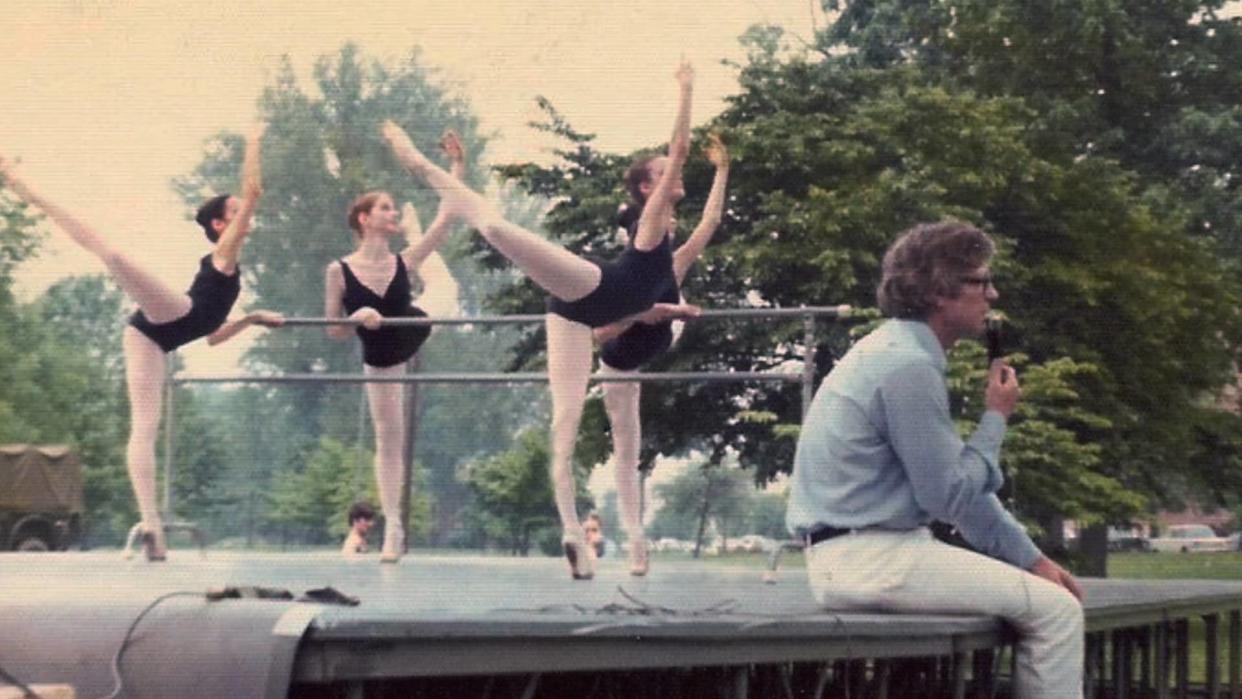 Ohio Ballet founder Heinz Poll sits on the stage as dancers rehearse at Reservoir Park in the early days of the company's free outdoor summer performances throughout Akron.