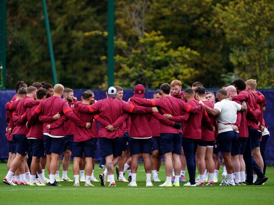 The England players in a group huddle as they prepare for Saturday’s semi-final against the defending champions  (PA)