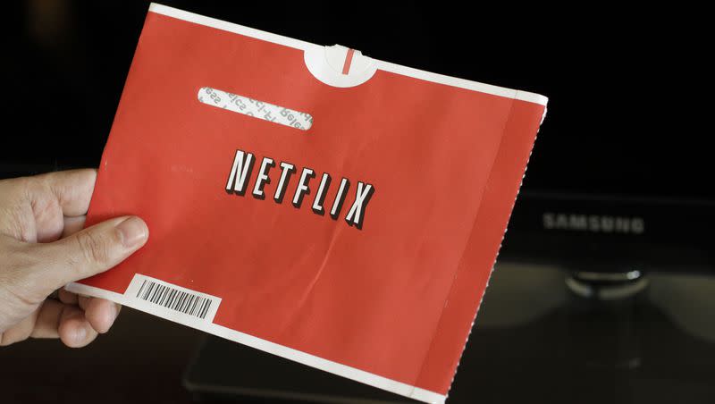 Customer holds The famous Netflix DVD red envelop.