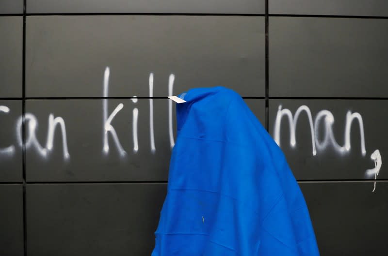 A protester covered with a blanket is pictured at the Hong Kong Polytechnic University (PolyU) in Hong Kong