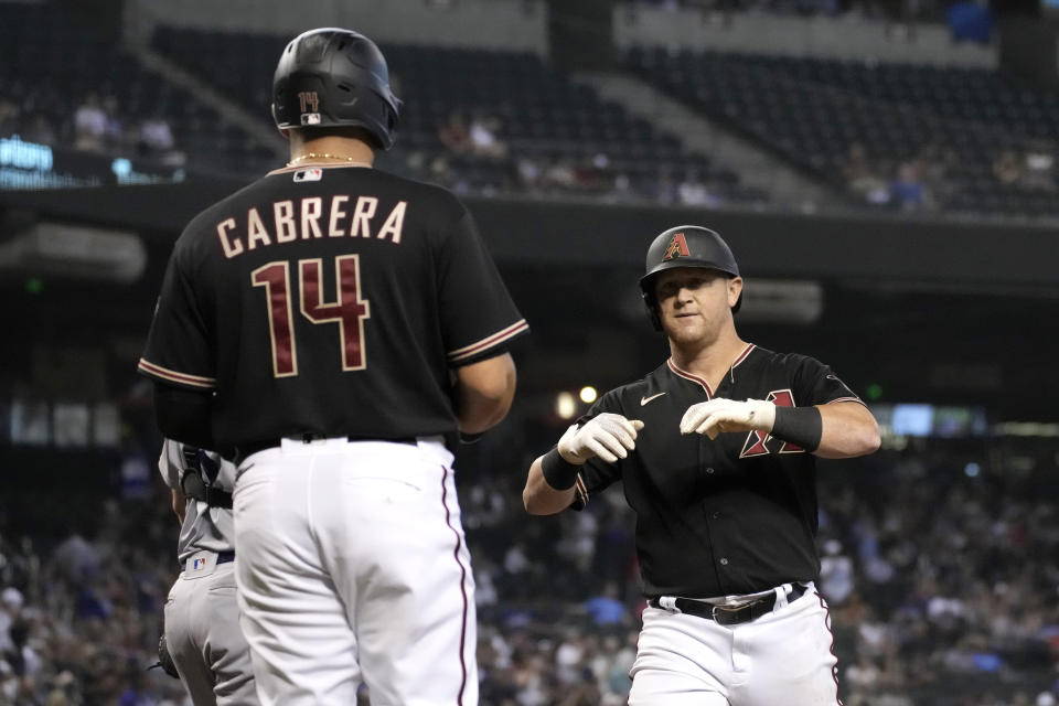 Arizona Diamondbacks' Kole Calhoun celebrates with Asdrubal Cabrera (14) after hitting a two-run home run against the Los Angeles Dodgers during the fourth inning of a baseball game Saturday, July 31, 2021, in Phoenix. (AP Photo/Rick Scuteri)