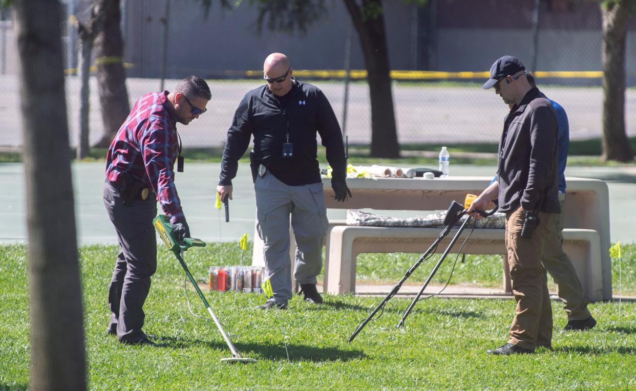 Stockton Police detectives comb Unity Park with metal detectors on Thursday, Apr. 13, 2023, the day after a Chavez High school student was killed in a shooting at the park.