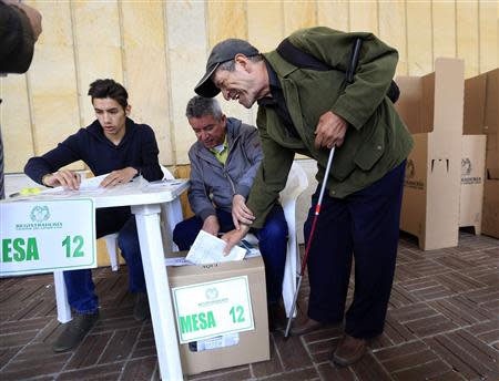 A blind voter casts his vote during the presidential elections in Bogota May 25, 2014. REUTERS/Jose Miguel Gomez