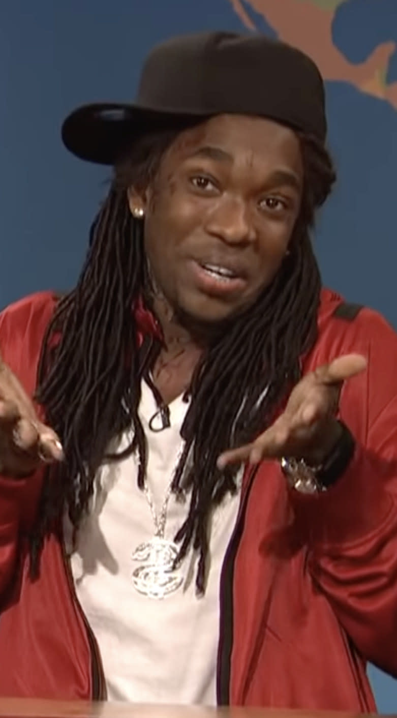 Pharoah wearing a sideways hat and chain on Weekend Update