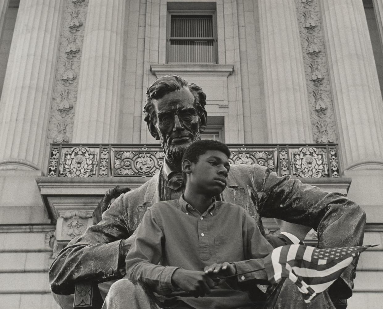 <span>A young boy sits on an Abraham Lincoln statue in front of San Francisco’s city hall during a NAACP-sponsored demonstration.</span><span>Photograph: Courtesy of the David Johnson Photograph Archive; the Bancroft Library; the University of California, Berkeley</span>