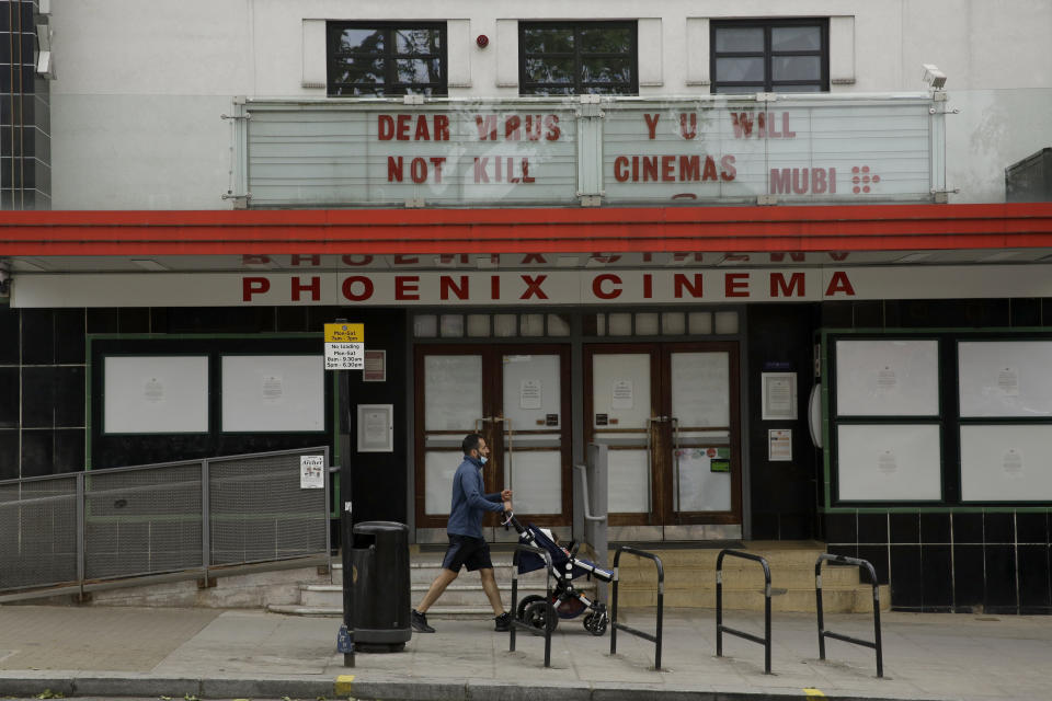 The independent Phoenix Cinema with a coronavirus message written where the name of a movie would normally appear, stands temporarily closed as part of the nationwide coronavirus lockdown in East Finchley, north London, Friday, May 22, 2020. (AP Photo/Matt Dunham)