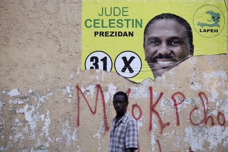 A man walks next to a ripped electoral poster of presidential candidate Jude Celestin in Port-au-Prince, Haiti, January 15, 2016. REUTERS/Andres Martinez Casares