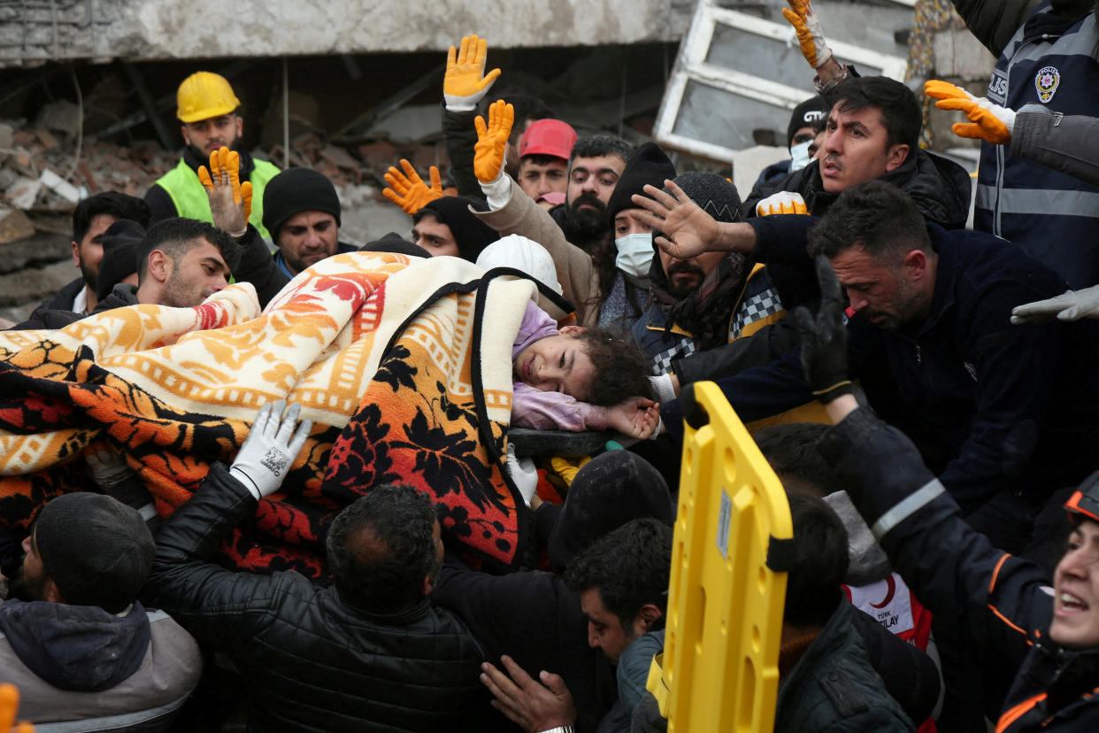 Rescuers carry a girl out from a collapsed building following an earthquake in Diyarbakir, Turkey.