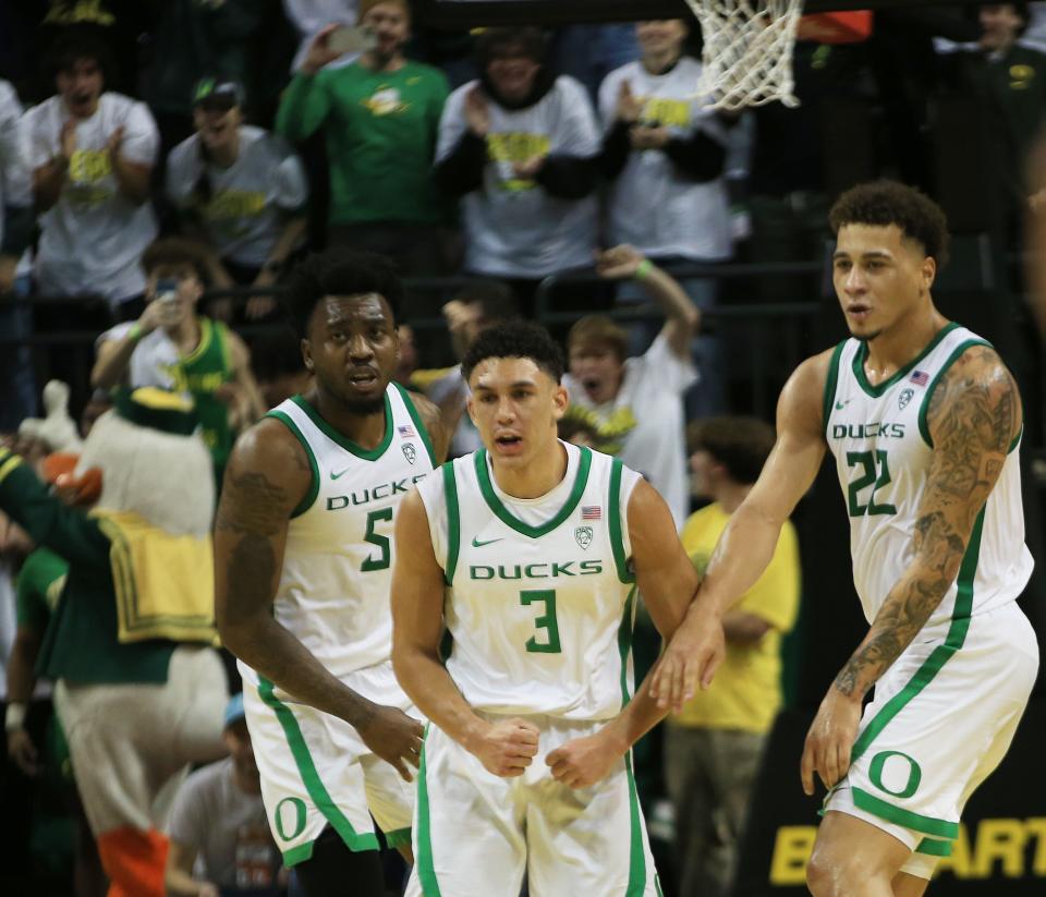 Oregon’s Jackson Shelstad, center, celebrates with teammates after sinking the game winning shot in overtime against Michigan at Matthew Knight Arena in Eugene Saturday, Dec 2, 2023.