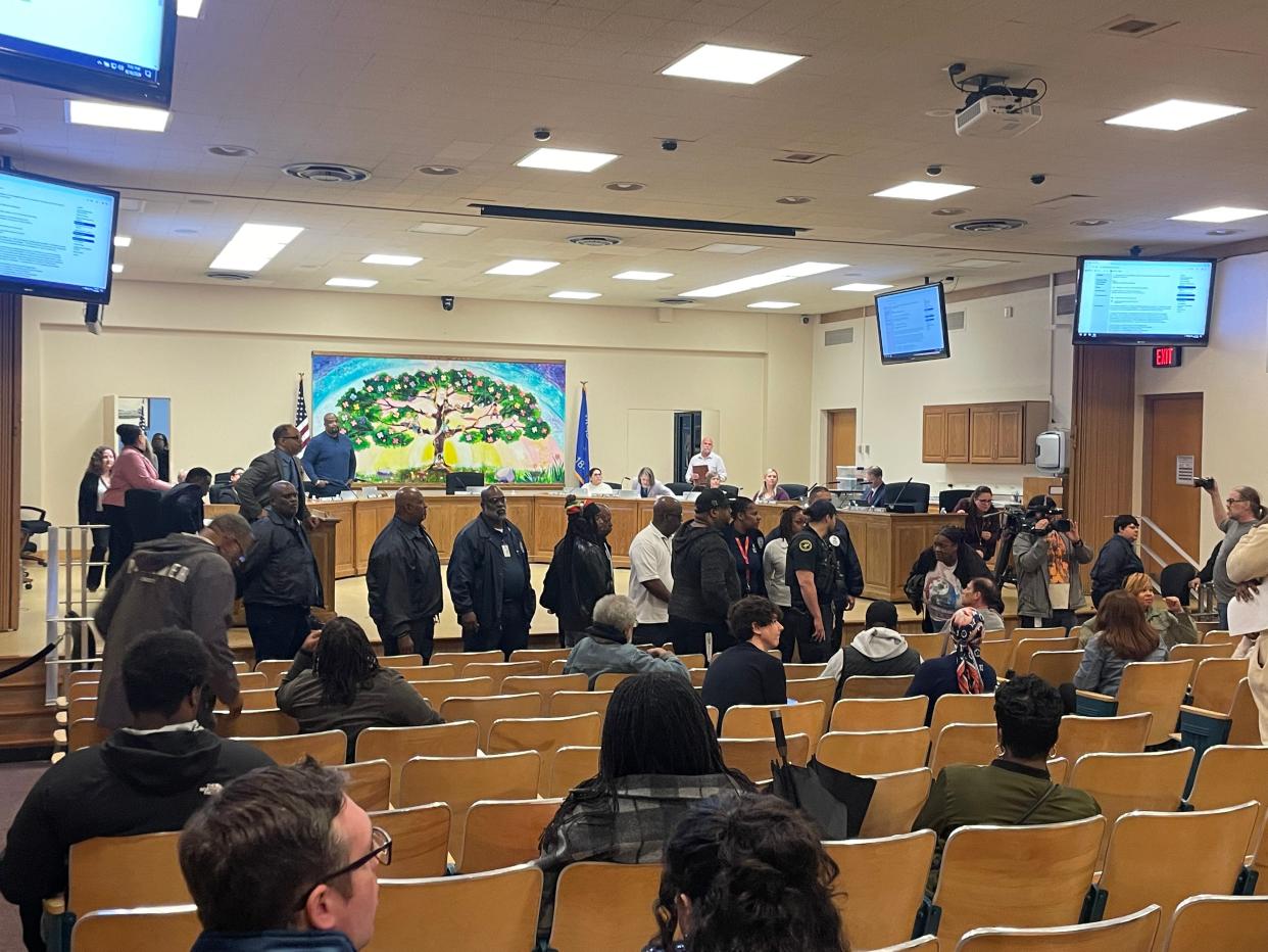 Security staff stand between the public and Milwaukee School Board members at a meeting April 18.