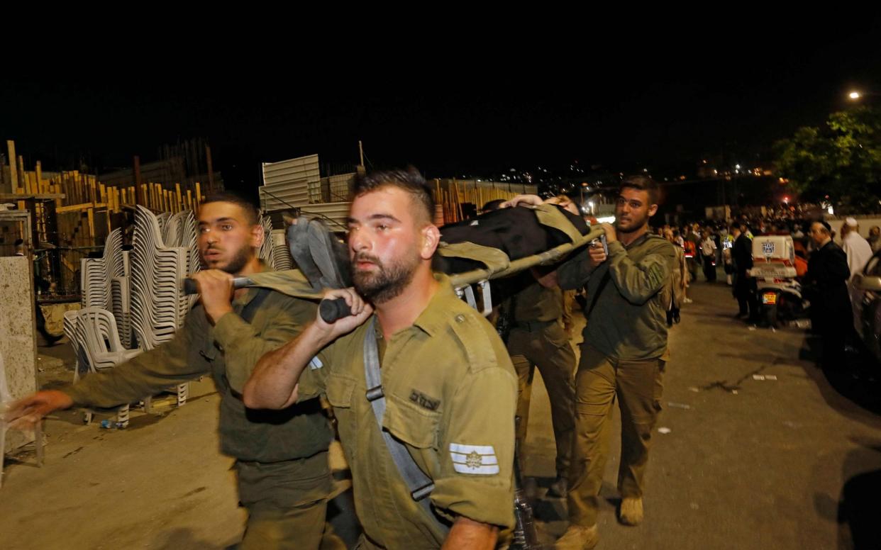 Members of the Israeli security forces evacuate an injured an ultra-Orthodox Jewish man after the collapse of grandstand seating at a synagogue in the Israeli settlement of Givat Zeev in the occupied West Bank outside Jerusalem. - Gil Cohen-Magen/AFP