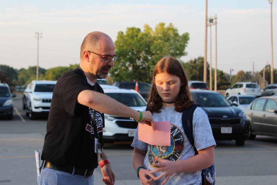 Edison Middle School Principal Brenden Whitfield helps a student on the first day of school, Sept. 5, in Green Bay.