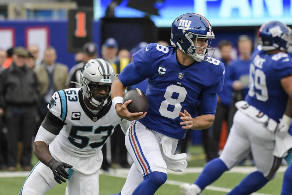 New York Giants quarterback Daniel Jones (8) rushes away from Carolina Panthers' Brian Burns (53) during the first half of an NFL football game, Sunday, Oct. 24, 2021, in East Rutherford, N.J. (AP Photo/Bill Kostroun)