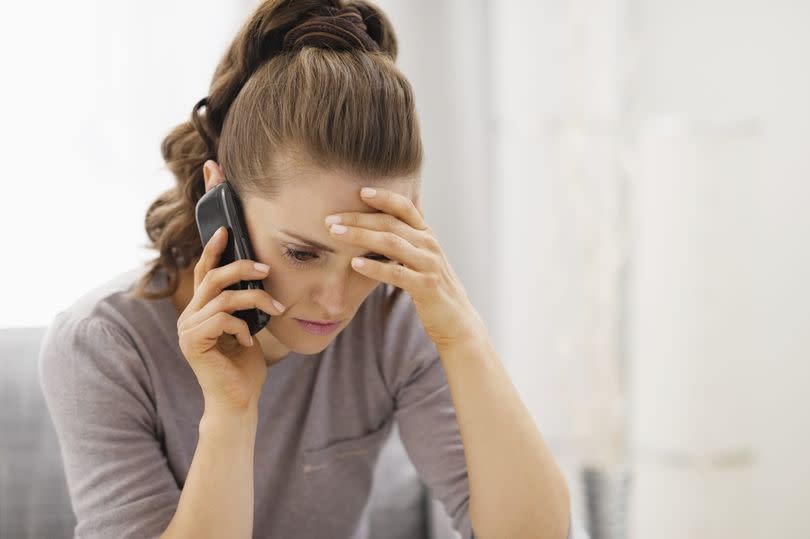 A woman on a phone looking worried