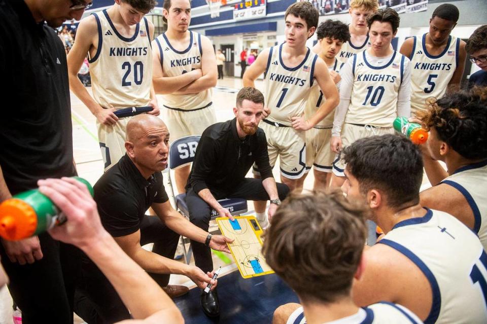 Stone Ridge Christian head coach Tyler Rogers and assist coach Hector Nava speak to their players between quarters of a NorCal Regional playoff game against Point Arena at Stone Ridge Christian High School in Merced, Calif., on Wednesday, Feb. 28, 2024. The Knights beat the Pirates 78-67.