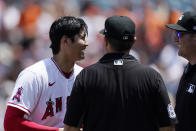 Los Angeles Angels starting pitcher Shohei Ohtani laughs after having his belt, glove and hat checked by umpires following the second inning of a baseball game against the San Francisco Giants Wednesday, June 23, 2021, in Anaheim, Calif. (AP Photo/Mark J. Terrill)