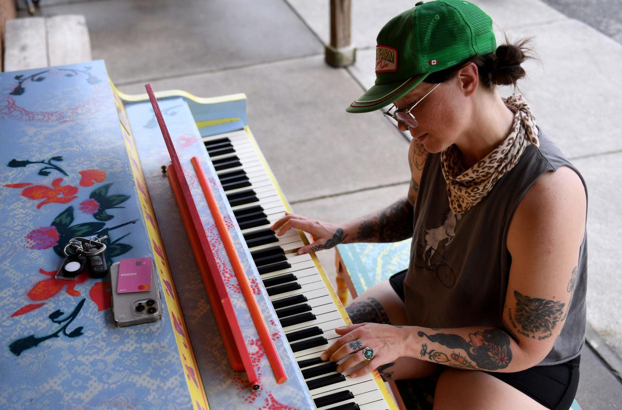 Darby Wilcox, local musician, plays the Please Play Me Piano, named Howard the Piano, located at Swamp Rabbit Cafe while she waits for her order on Tuesday, June 18, 2024. The piano was painted by Crosby Jack.