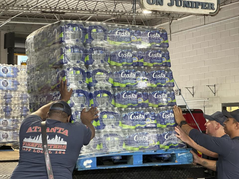 Atlanta firefighters unload bottled water to distribute to residents at a fire station in the city's Midtown neighborhood on Monday, June 3, 2024. A swath of the city remained under an order to boil water before drinking after a pair of major water leaks (AP Photo/Jeff Amy)