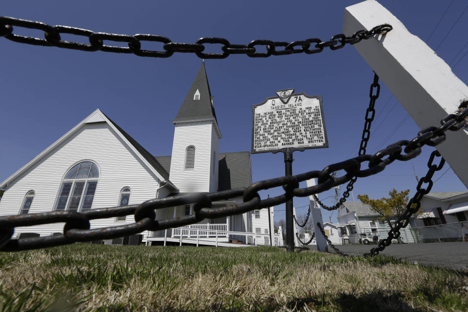 FILE - This Wednesday April 3, 2013 file photo shows a chain fence surrounding the Swain Memorial Church in Tangier Island, Va. The fishing community in the middle of the Chesapeake Bay has reported zero cases of the coronavirus. But the virus would be devastating if it were to reach the island, which has a large elderly population and no full-time doctor. (AP Photo/Steve Helber)