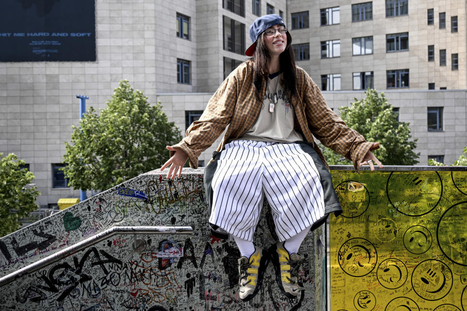 Billie Eilish sentada en el barandal de una escalera conocida como "la pared de Billie Eilish" en Berlín el viernes 7 de junio de 2024. (Britta Pedersen/dpa vía AP)