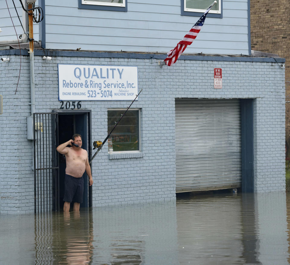 David Fox makes a call from his business on Poydras Street in New Orleans after flooding in New Orleans Wednesday, July 10, 2019. A storm swamped New Orleans streets and paralyzed rush-hour traffic Wednesday as concerns grew that even worse weather was on the way. (AP Photo/Matthew Hinton)