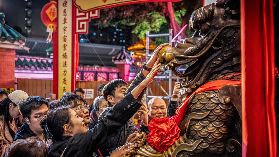 People gather in front of a dragon statue at the Wong Tai Sin Taoist temple in Hong Kong on February 9, 2024. - Alex Chan Tsz Yuk/SOPA Images/LightRocket/Getty Images