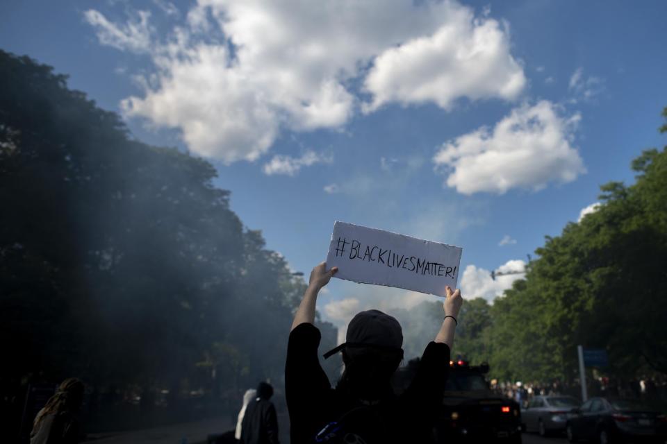 A protester holds a sign stating "BLACK LIVES MATTER" towards police shooting tear gas after a march through Center City on June 1, 2020 in Philadelphia, Pennsylvania: Mark Makela/Getty Images