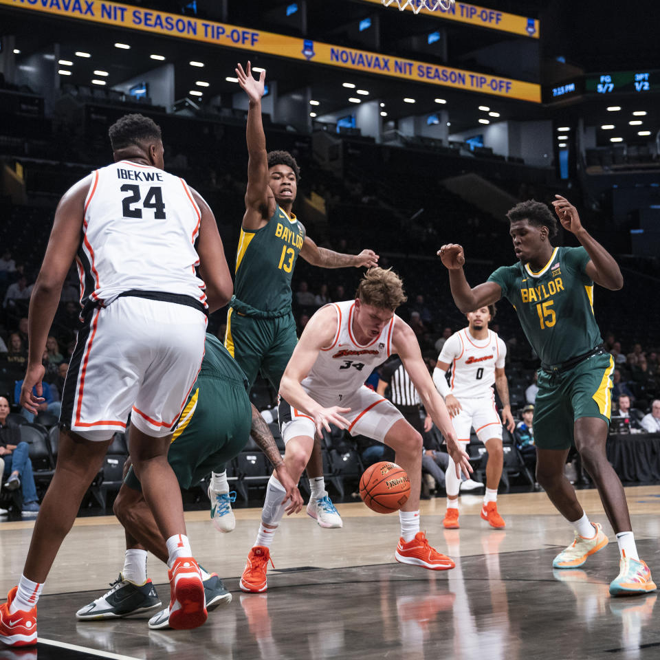 Oregon State forward Tyler Bilodeau (34) reaches for the ball between Baylor forward Josh Ojianwuna (15) and forward Langston Love (13) during the first half of an NCAA college basketball game Wednesday, Nov. 22, 2023, in New York. (AP Photo/Eduardo Munoz Alvarez)