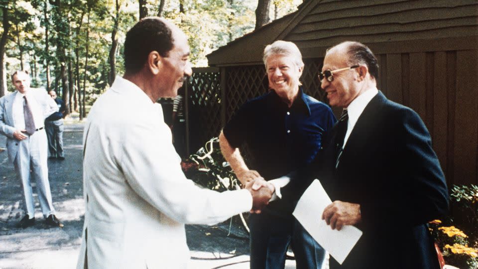 Carter watches as Egyptian President Anwar al-Sadat shakes hands with Israel's Menachem Begin at Camp David in 1978. - Consolidated News/AFP/Getty Images