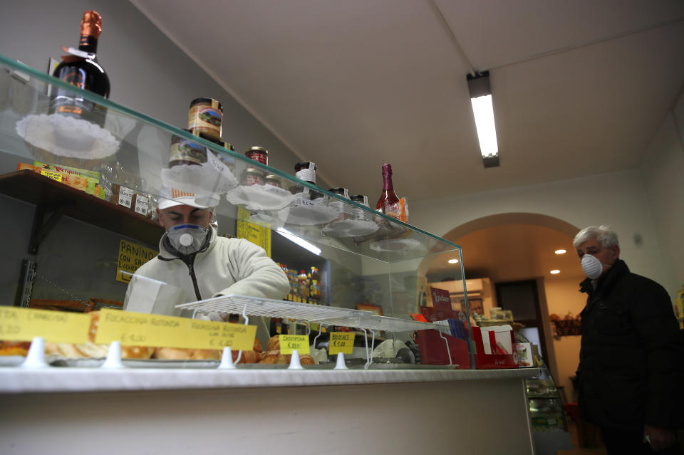 In this photo taken on Thursday, March 12, 2020, Roberto Zamproni works in his deli meat and cold cuts shop in Codogno, Italy. The northern Italian town that recorded Italy’s first coronavirus infection has offered a virtuous example to fellow Italians, now facing an unprecedented nationwide lockdown, that by staying home, trends can reverse. Infections of the new virus have not stopped in Codogno, which still has registered the most of any of the 10 Lombardy towns Italy’s original red zone, but they have slowed. For most people, the new coronavirus causes only mild or moderate symptoms. For some it can cause more severe illness. (AP Photo/Antonio Calanni)