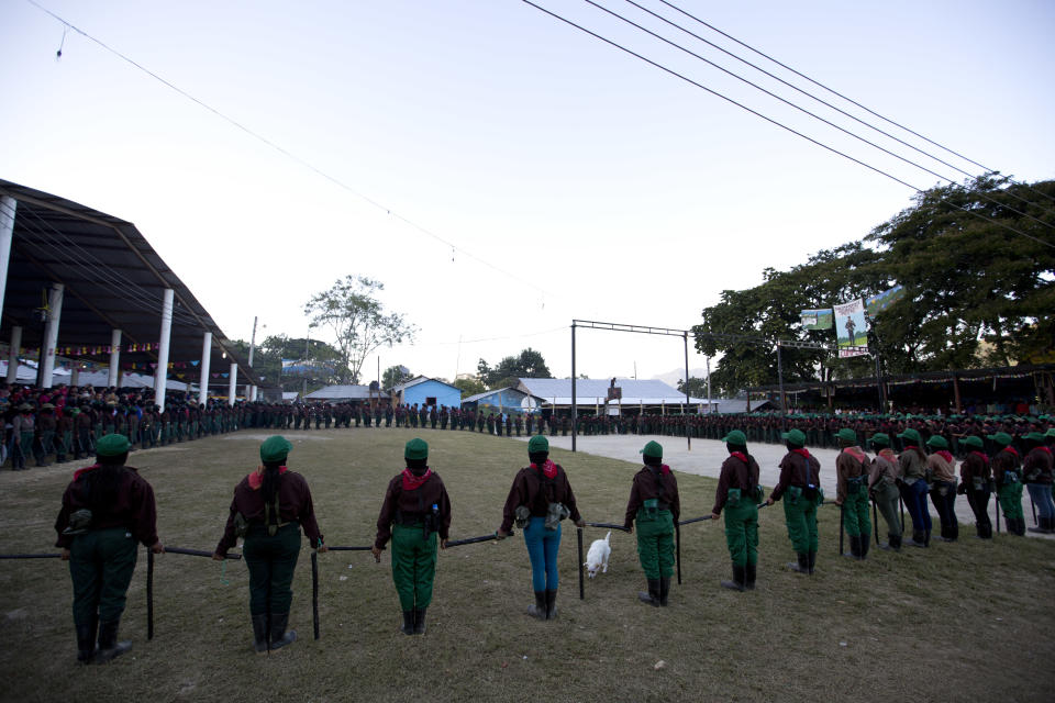 Zapatista National Liberation Army, EZLN, militia hold a perimeter during an event marking the 25th anniversary of the Zapatista uprising, in La Realidad, Chiapas state, Mexico, late Monday, Dec. 31, 2018. (AP Photo/Eduardo Verdugo)