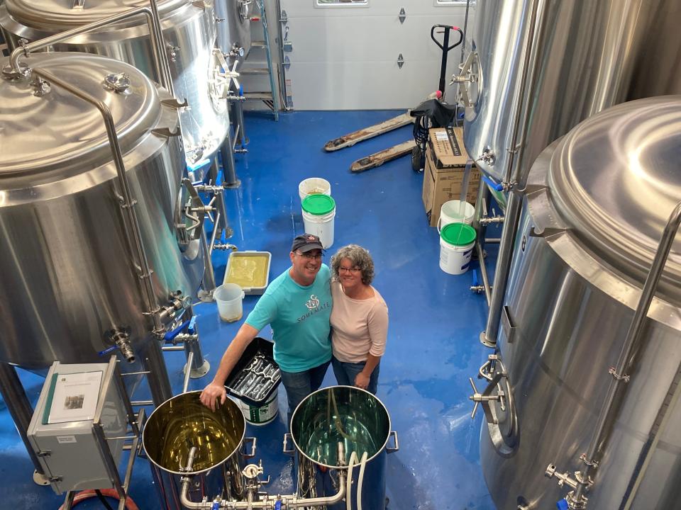 Jonathan and Carol Mogor, owners of Soulmate Brewing, stand among the brewing tanks at the Morrisville business Sept. 14, 2023.