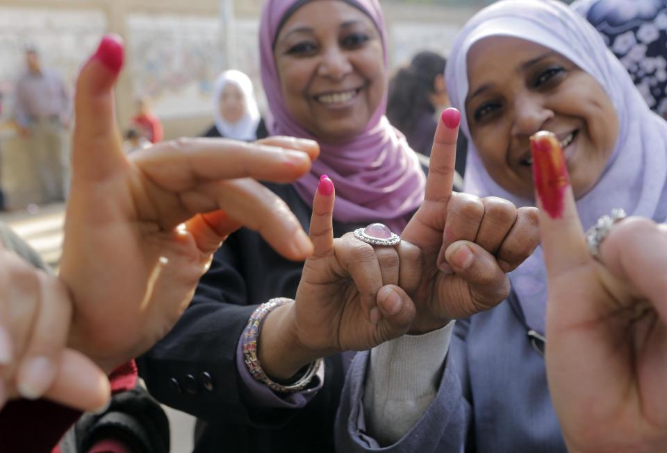 Egyptian women show their inked fingers after casting their votes at a polling station in Cairo, Tuesday, Jan. 14, 2014. Egyptians are voting on a draft for their country's new constitution that represents a key milestone in a military-backed roadmap put in place after President Mohammed Morsi was overthrown in a popularly backed coup last July. (AP Photo/Amr Nabil)