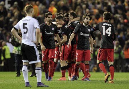 Football Soccer - Valencia vs Athletic Bilbao - Europa League Group Stage - Round of 16 second leg - Mestalla Stadium, Valencia, Spain, 17/03/16.Athletic Bilbao's players celebrate next to Valencia's Shkodran Mustafi after the match. REUTERS/Heino Kalis