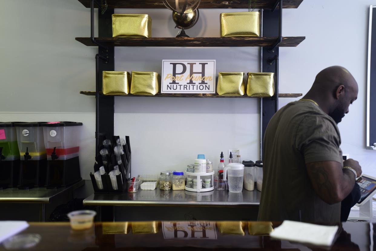 Co-owner of Port Huron Nutrition Clifton Jackson tends to a customer at the register at Port Huron Nutrition located at 506 Quay Street in downtown Port Huron on Thursday, May 19, 2022.