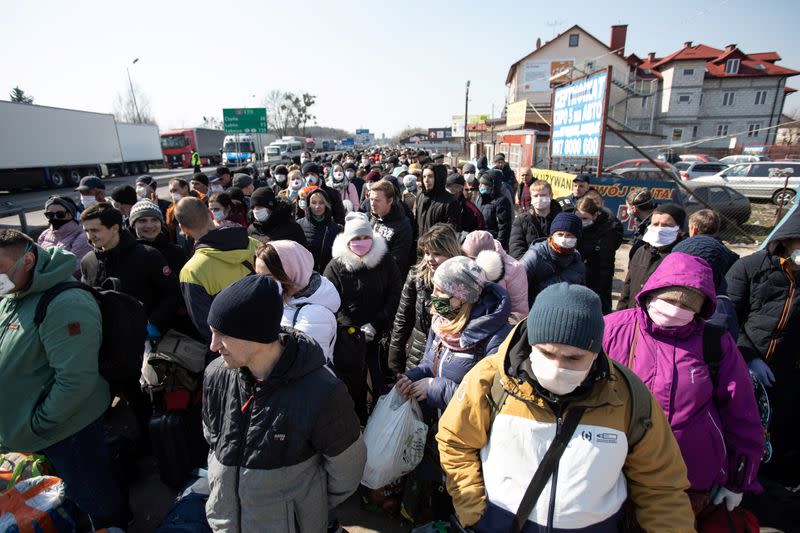 People queue to cross to Ukraine at the border crossing in Dorohusk