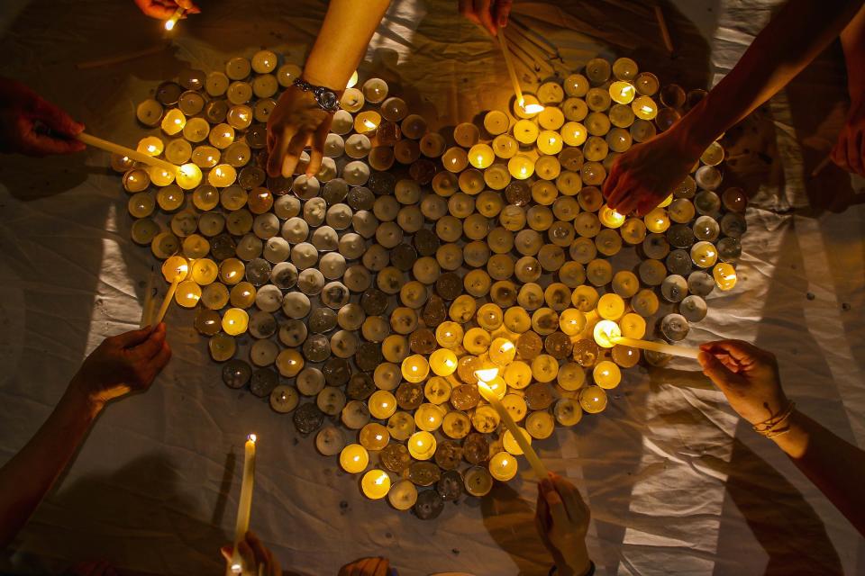 People light up candles during a "Love U MH370" event in Kuala Lumpur