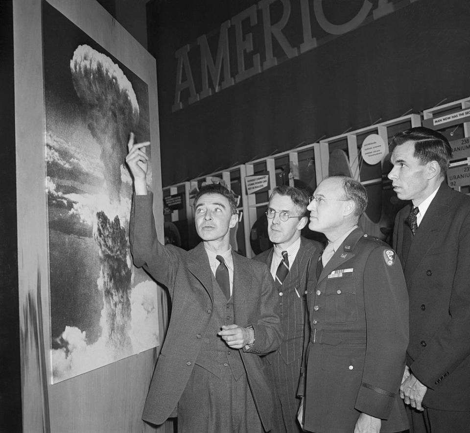 Soldiers looking at a poster of the atomic bomb blast