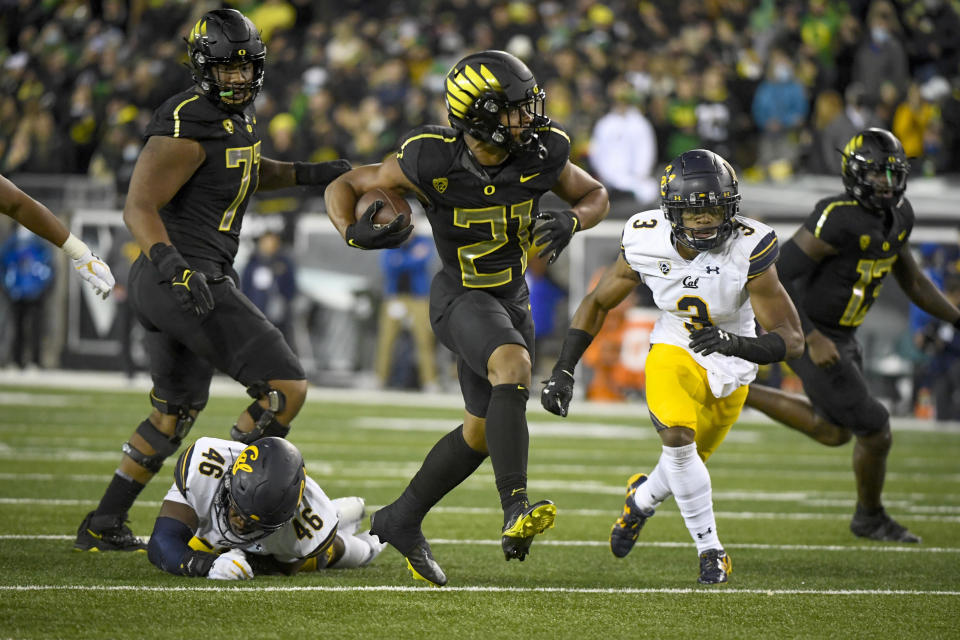 Oregon running back Byron Cardwell (21) runs past California linebacker Marqez Bimage (46) and California safety Elijah Hicks (3) during the fourth quarter of an NCAA college football game Friday, Oct. 15, 2021, in Eugene, Ore. (AP Photo/Andy Nelson)