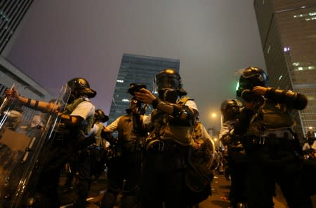 Riot police prepare their gear during a demonstration against a proposed extradition bill in Hong Kong