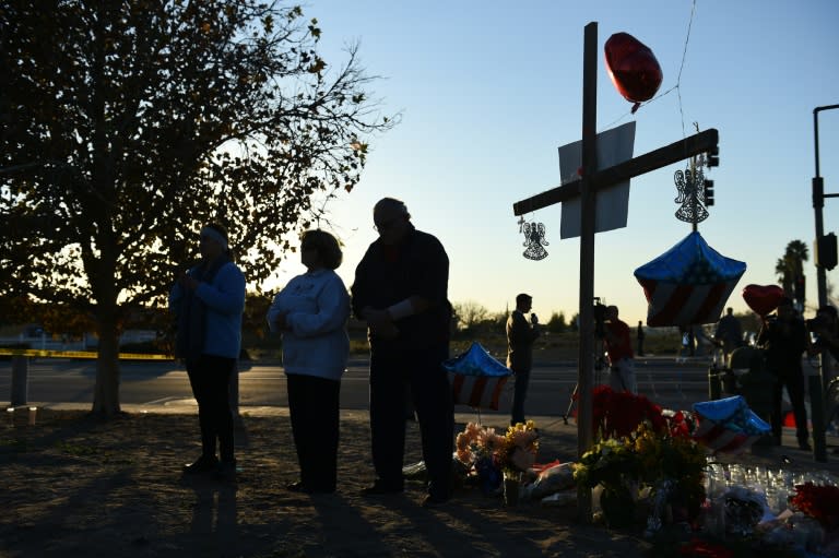People pray at a makeshift memorial for the victims of a mass shooting near the Inland Regional Center in San Bernardino, California on December 4, 2015