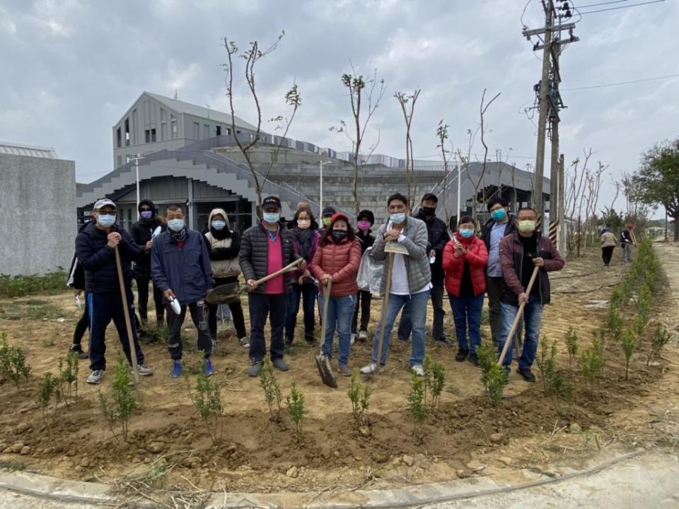 台南市農產運銷公司全體員工拿著鋤頭，在新化果菜市場種植綠籬。  （記者張淑娟攝）