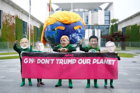 Activists hold a banner, behind a giant globe, as they protest in front of Chancellery in Berlin, Germany June 29, 2017. REUTERS/Hannibal Hanschke